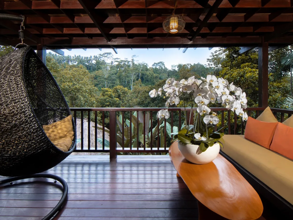 Private balcony of the Jungle View Villa with hanging chair and rainforest views in Ubud, Bali
